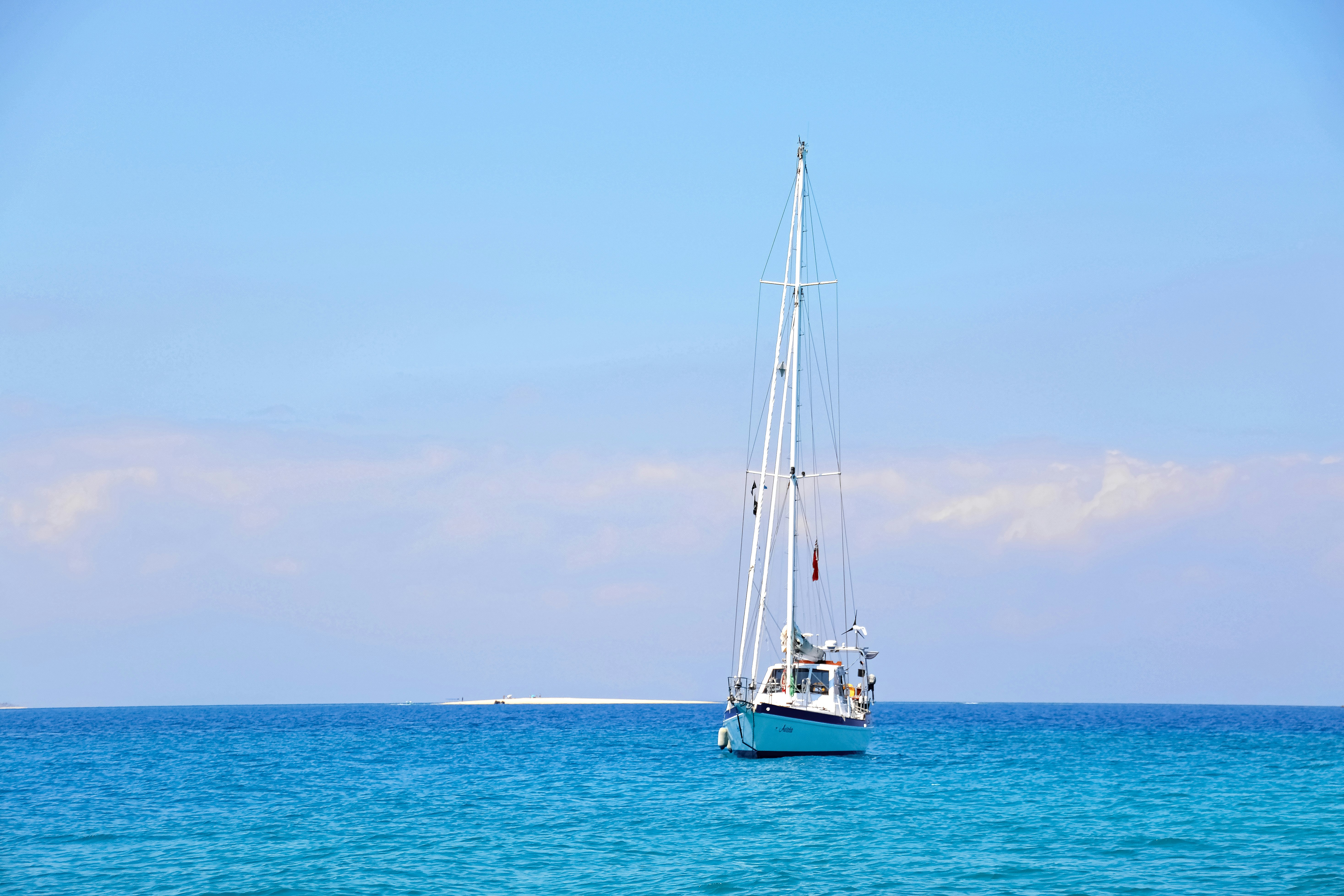 white sail boat on sea during daytime